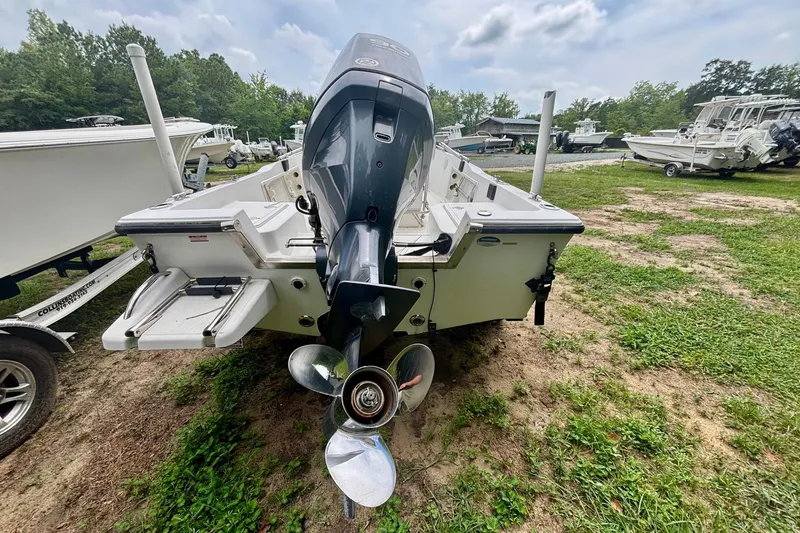 Slide: The Image of 2011 Key West 1720 Center Console boat with outboard motor, parked on grass. - 3