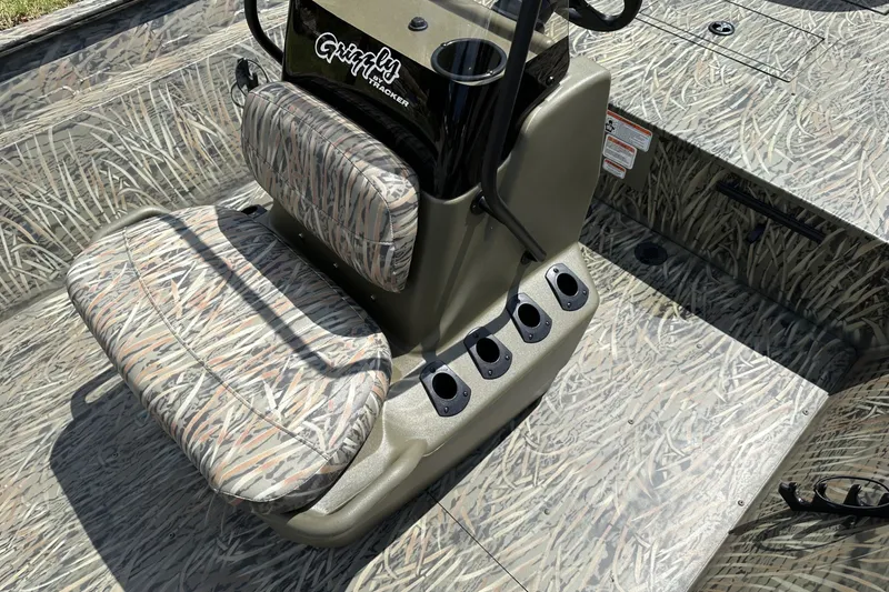 Slide: The Image of 2026 Tracker Grizzly 2072 CC boat interior with camo seats and console. - 14
