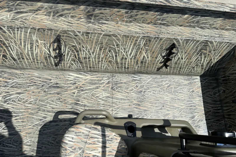 Slide: The Image of Camouflage interior of 2026 Tracker Grizzly 2072 CC boat with rod holders. - 15