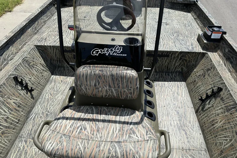 Slide: The Image of 2026 Tracker Grizzly 2072 CC boat interior with camouflage seating and steering console. - 13