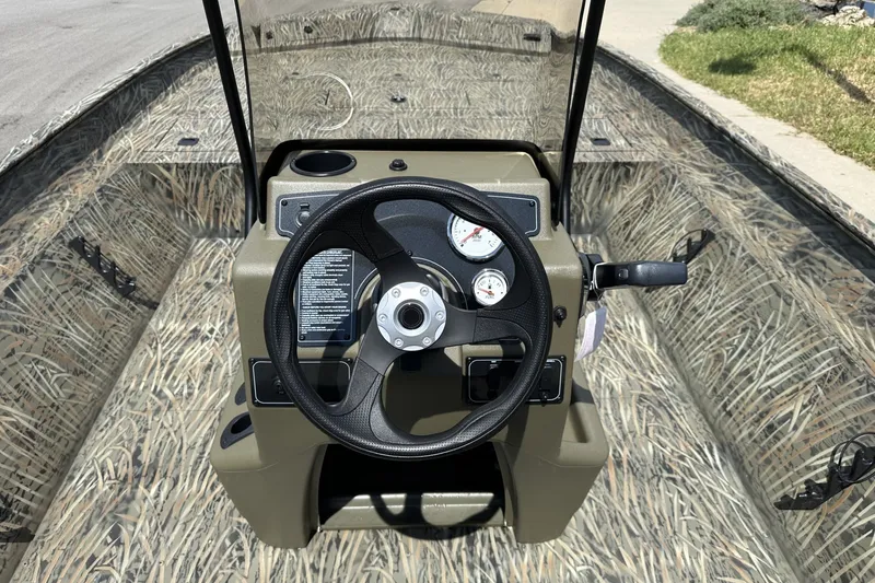 Slide: The Image of 2026 Tracker Grizzly 2072 CC boat dashboard with camo design and steering wheel. - 17