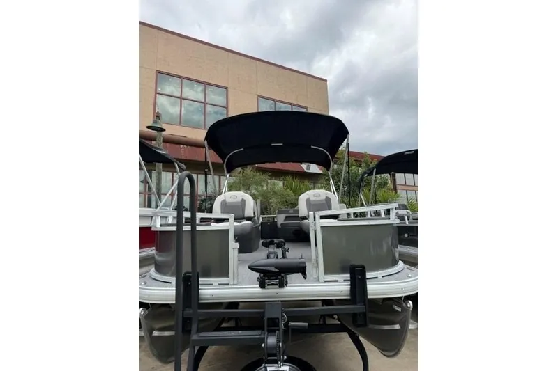 The Image of 2026 Sun Tracker Party Barge 18 DLX pontoon boat with canopy, parked outdoors. - 0