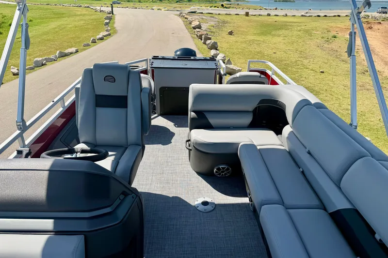 Slide: The Image of 2026 Sun Tracker Sportfish 24 XP3 pontoon boat interior with plush seating and steering console. - 5