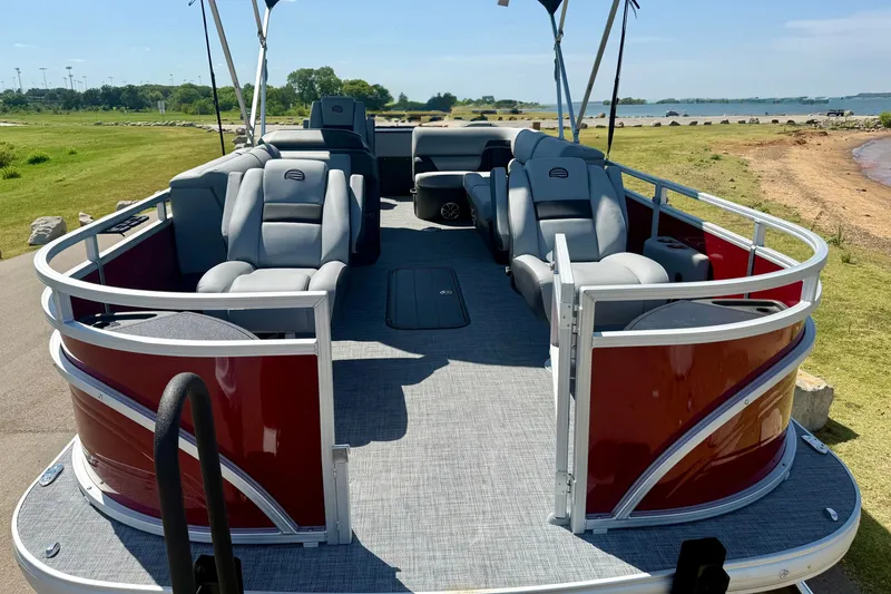 Slide: The Image of 2026 Sun Tracker Sportfish 24 XP3 pontoon boat with spacious seating, docked by a scenic shoreline. - 4