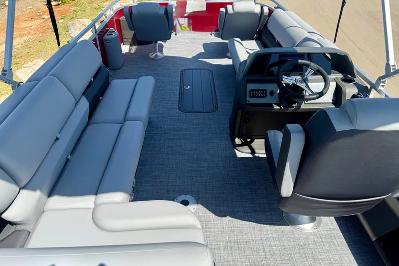 Slide: The Image of 2026 Sun Tracker Sportfish 24 XP3 pontoon boat interior with gray seating and steering console. - 6