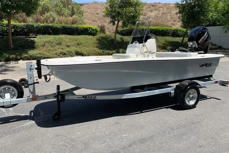 Slide: The Image of 2026 Mako Pro Skiff 13 CC boat on trailer, parked outdoors. - 2