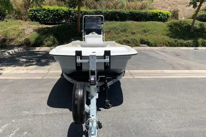 Slide: The Image of 2026 Mako Pro Skiff 13 CC on trailer, parked outdoors in sunny setting. - 9