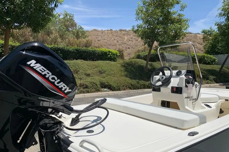 Slide: The Image of 2026 Mako Pro Skiff 13 CC boat with Mercury engine, parked outdoors. - 8