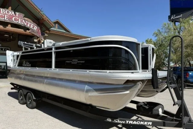 The Image of 2026 Sun Tracker Party Barge 22 RF XP3 pontoon boat on trailer outside dealership. - 0