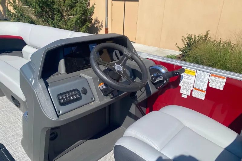 Slide: The Image of Interior view of 2026 Sun Tracker Party Barge 22 RF XP3, featuring steering console and seating. - 10