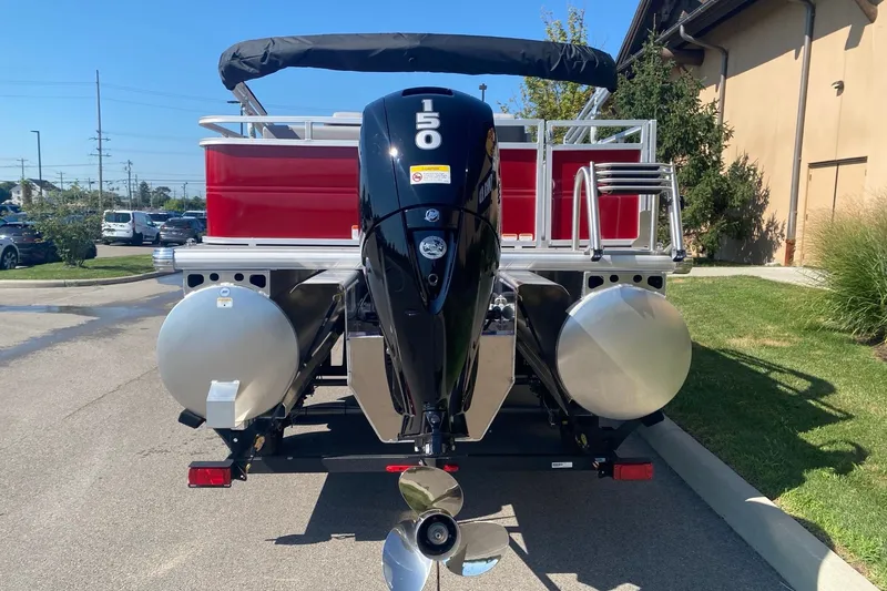 Slide: The Image of 2026 Sun Tracker Party Barge 22 RF XP3 with powerful outboard motor, parked outdoors. - 4