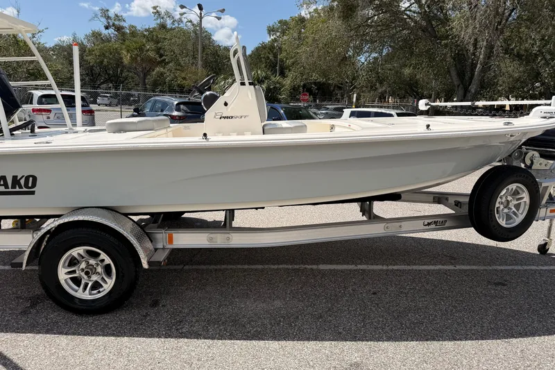 Slide: The Image of 2026 Mako 18 Pro Skiff boat on trailer, parked outdoors under a clear sky. - 1