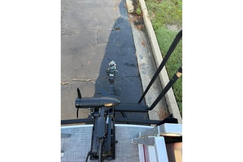 Slide: The Image of 2026 Sun Tracker SportFish 20 DLX boat trailer hitch and motor, parked on pavement. - 17