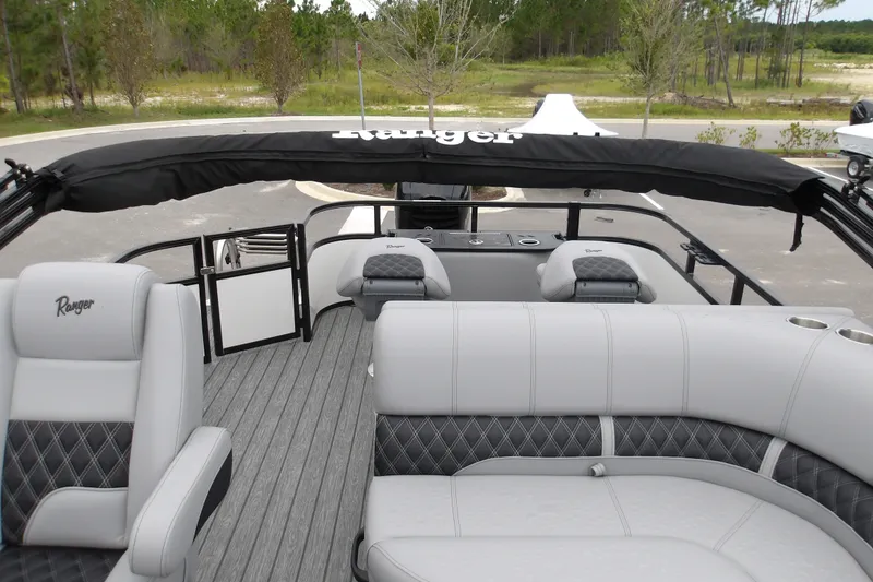 Slide: The Image of 2026 Ranger 220F boat interior with gray seating and black canopy in a scenic outdoor setting. - 14