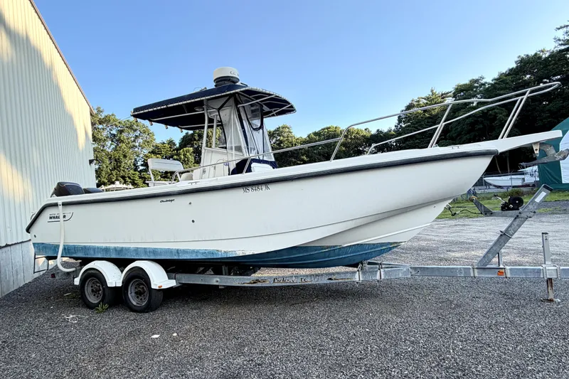 The Image of 2000 Boston Whaler 260 Outrage boat on trailer, parked outdoors. - 1