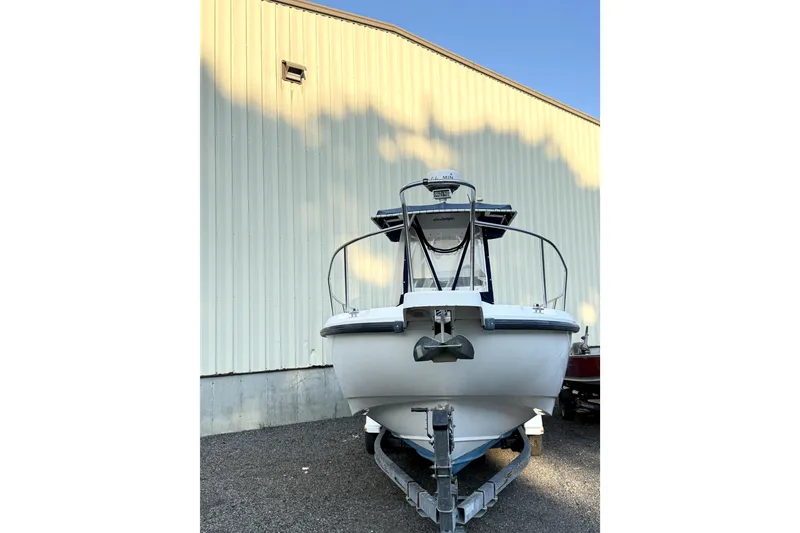 Slide: The Image of Front view of a 2000 Boston Whaler 260 Outrage boat on a trailer. - 4