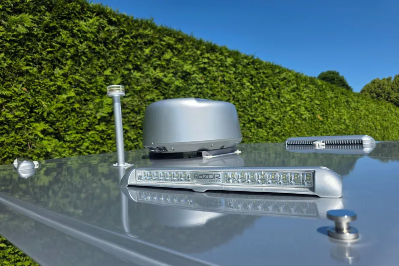 Slide: The Image of Rooftop equipment on 2025 Iguana Commuter against a lush green hedge background. - 9