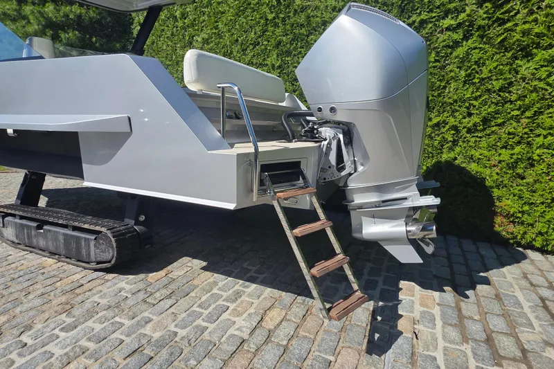 Slide: The Image of 2025 Iguana Commuter with outboard motor and retractable ladder on cobblestone surface. - 4