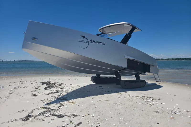 Slide: The Image of Futuristic 2025 Iguana Commuter yacht with tracks on a sandy beach. - 1
