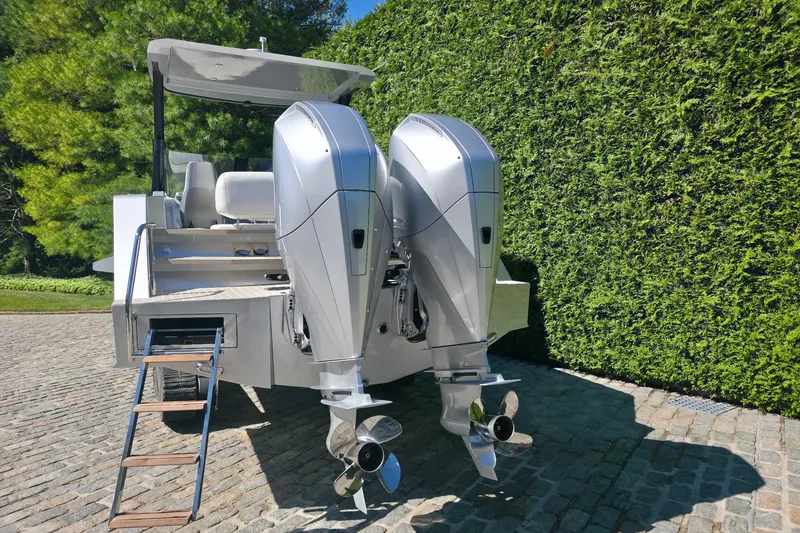 Slide: The Image of 2025 Iguana Commuter boat with dual outboard motors on cobblestone driveway. - 3