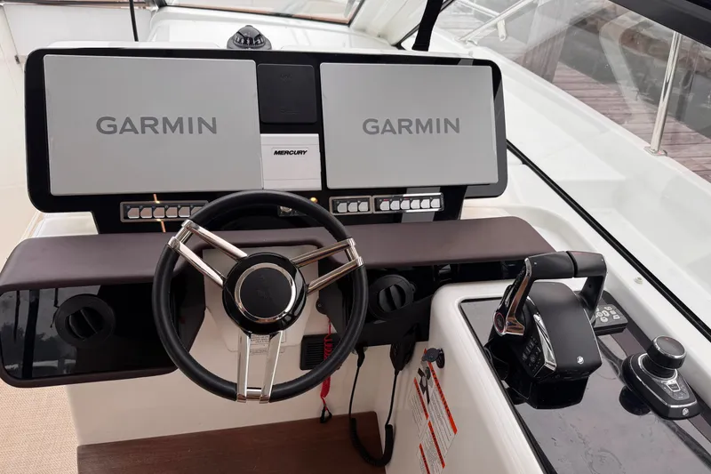 Slide: The Image of Helm of 2025 Four Winns TH36 boat with Garmin navigation displays and Mercury controls. - 18