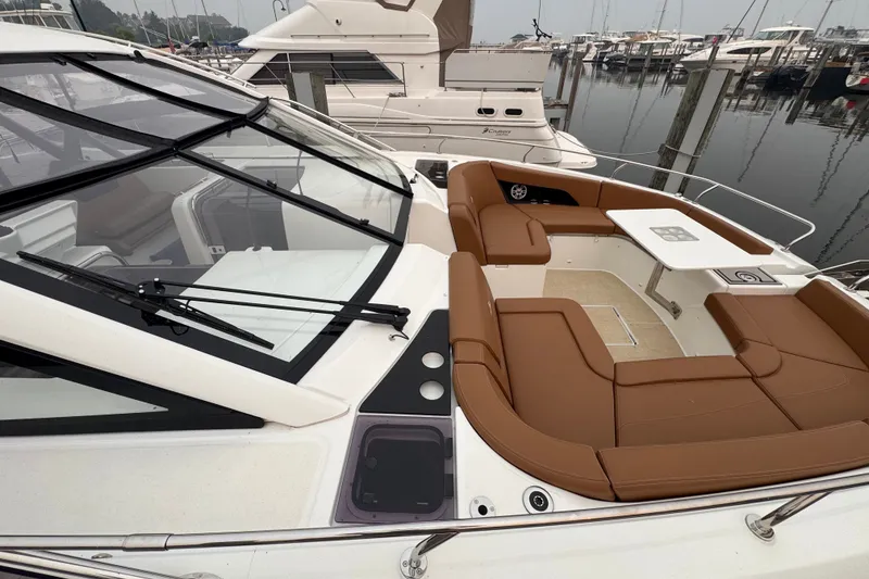 Slide: The Image of 2025 Four Winns TH36 yacht with brown seating and table, docked at marina. - 40