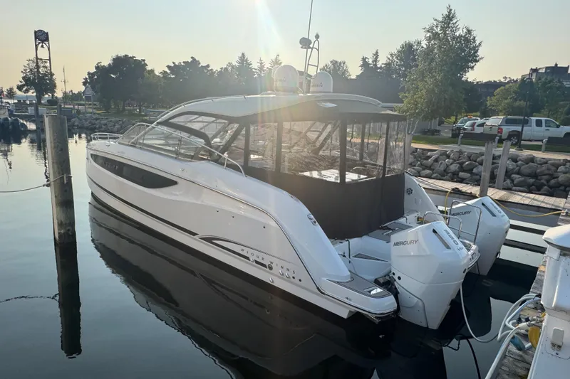 Slide: The Image of 2025 Four Winns TH36 boat docked at marina with Mercury engines. - 2