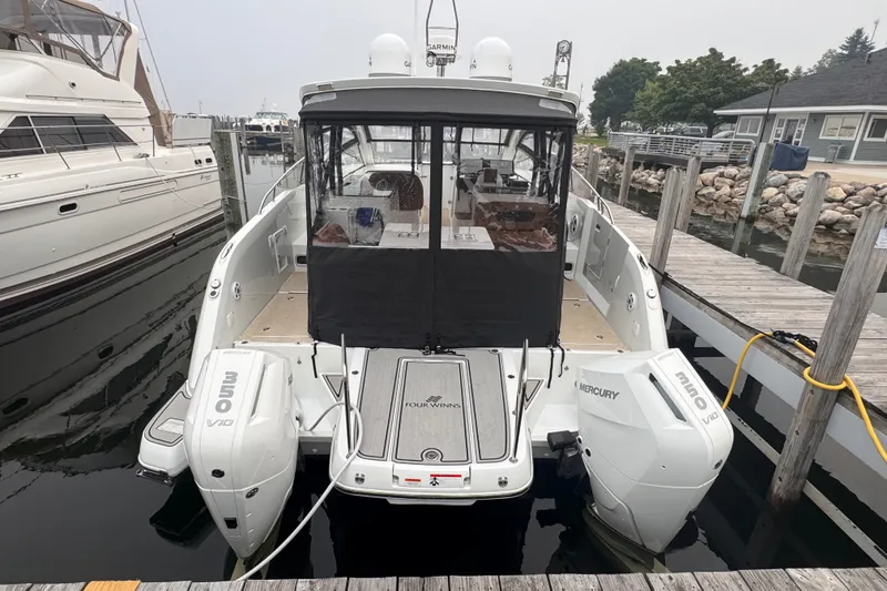 Slide: The Image of 2025 Four Winns TH36 boat docked, featuring dual Mercury V10 outboard engines. - 7