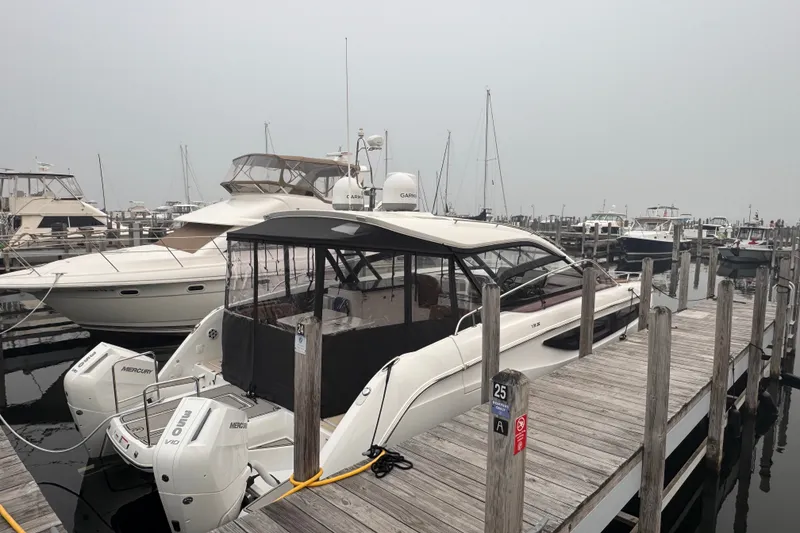 Slide: The Image of 2025 Four Winns TH36 boat docked at a marina with twin Mercury engines. - 5