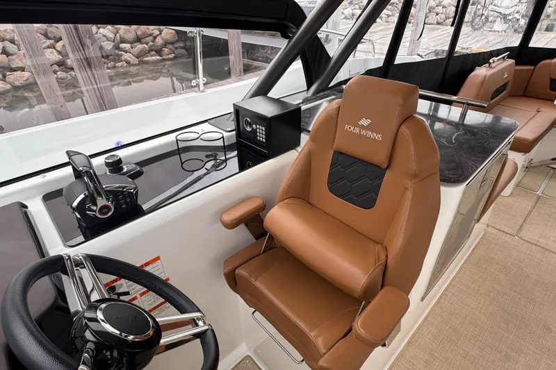 Slide: The Image of 2025 Four Winns TH36 boat interior with luxurious leather seating and modern helm controls. - 20