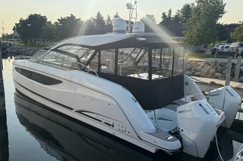 The Image of 2025 Four Winns TH36 boat docked, featuring sleek design and Mercury engines. - 0
