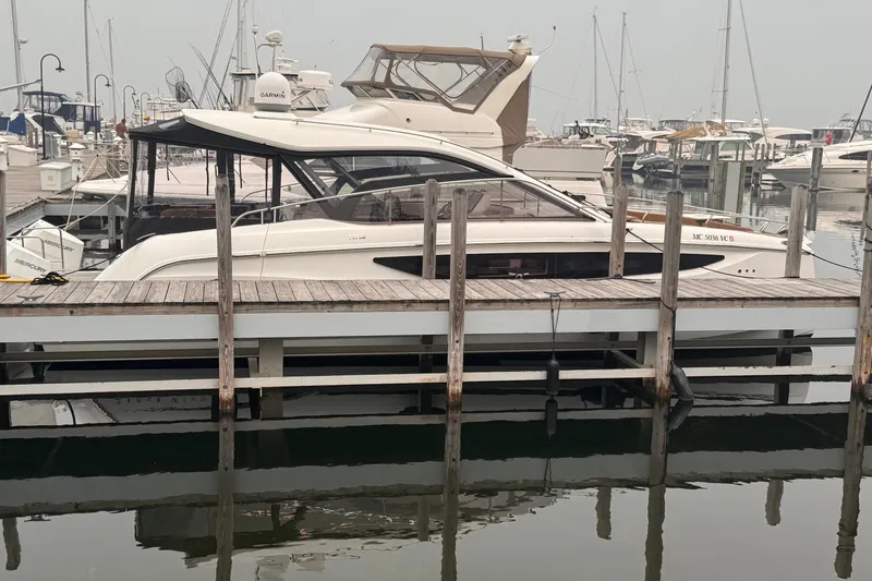 Slide: The Image of 2025 Four Winns TH36 yacht docked at a marina, surrounded by other boats. - 6
