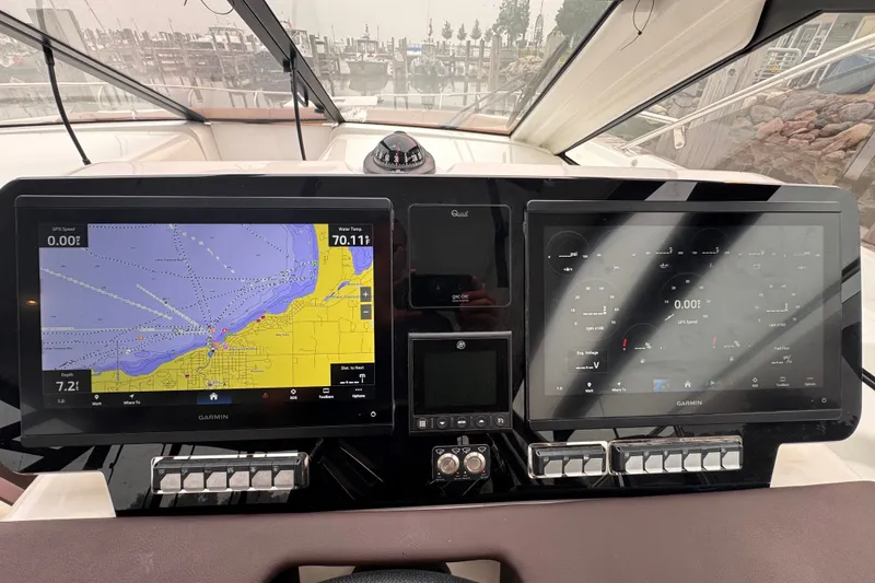 Slide: The Image of 2025 Four Winns TH36 dashboard with dual Garmin navigation screens displaying maps and controls. - 37