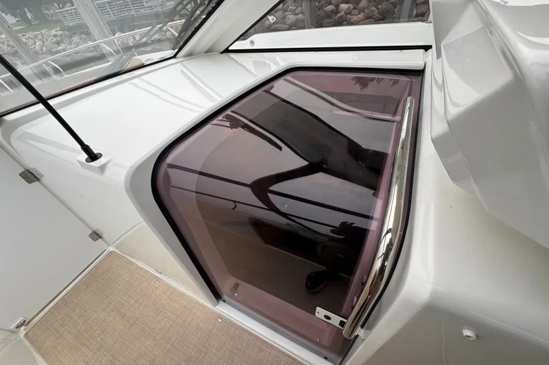 Slide: The Image of 2025 Four Winns TH36 boat cabin entrance with tinted sliding door. - 30