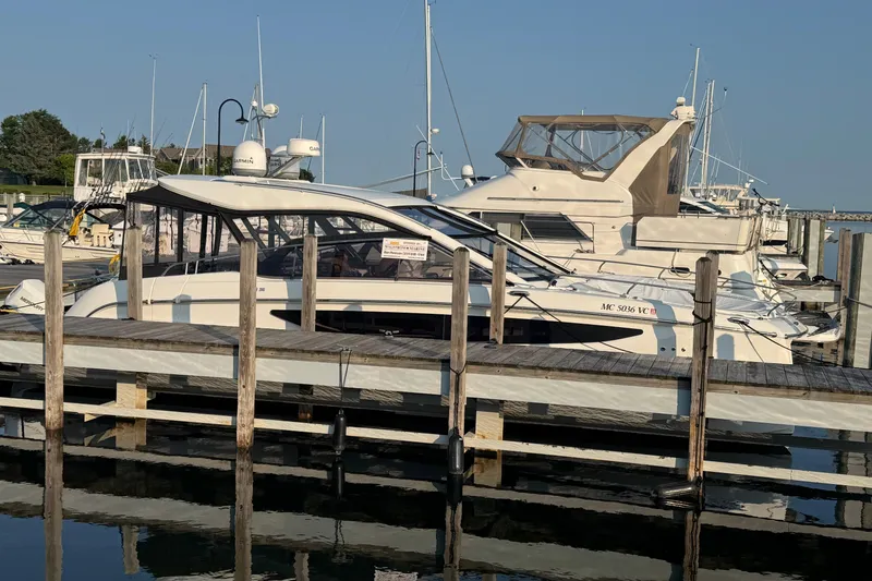 Slide: The Image of 2025 Four Winns TH36 yacht docked at marina under clear blue sky. - 1