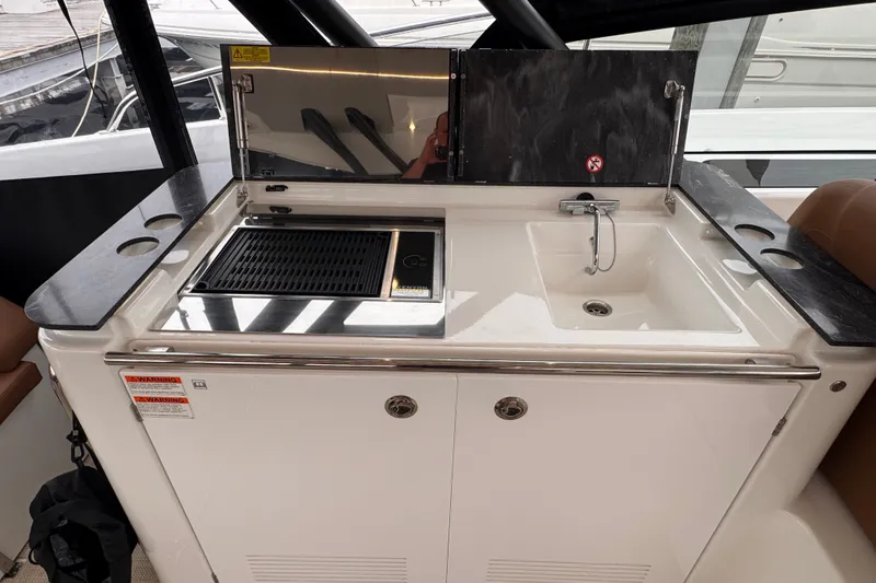 Slide: The Image of Outdoor kitchen on 2025 Four Winns TH36 yacht with grill and sink. - 21