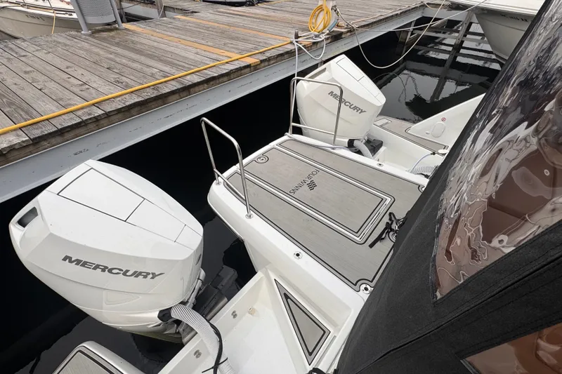 Slide: The Image of 2025 Four Winns TH36 boat with twin Mercury engines docked at a marina. - 12