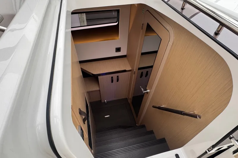 Slide: The Image of Interior view of 2025 Four Winns TH36 yacht, featuring sleek wooden stairs and modern design. - 23