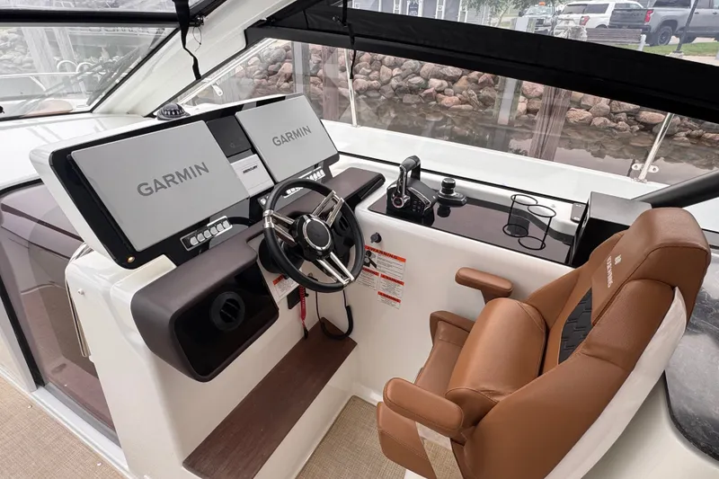 Slide: The Image of 2025 Four Winns TH36 helm with dual Garmin displays and luxurious captain's chair. - 19