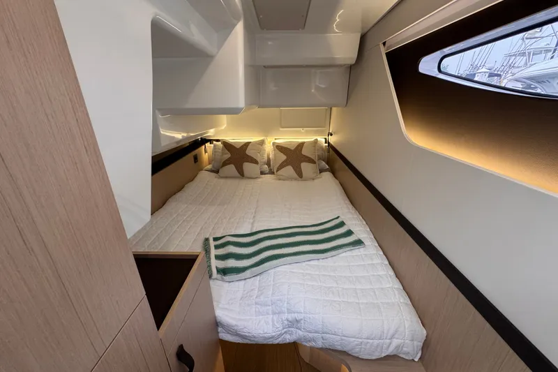 Slide: The Image of Luxurious cabin interior of 2025 Four Winns TH36 yacht, featuring cozy bedding and modern design. - 25