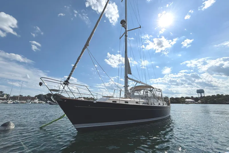 Slide: The Image of Sailboat on water, 2002 Passport 470 Center Cockpit, under sunny sky with clouds. - 5