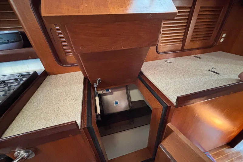 Slide: The Image of Interior of 2002 Passport 470 Center Cockpit yacht, featuring wooden cabinetry and storage compartments. - 56