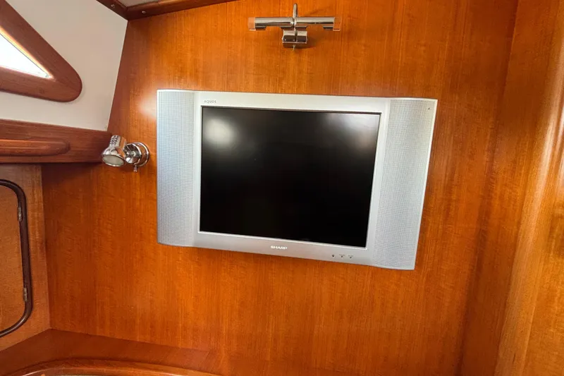 Slide: The Image of Sharp Aquos TV mounted on wooden wall inside 2002 Passport 470 Center Cockpit yacht. - 42