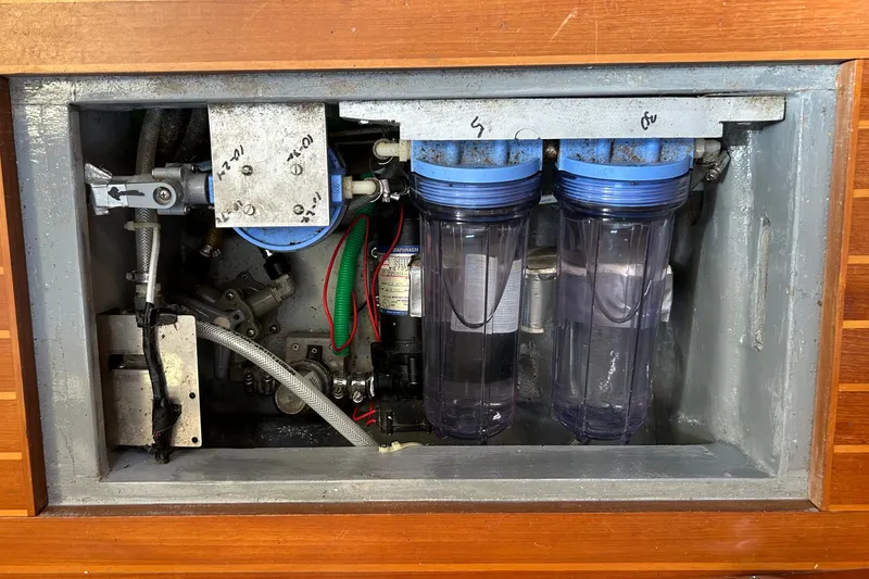 Slide: The Image of Engine compartment of a 2002 Passport 470 Center Cockpit with visible filters and hoses. - 86