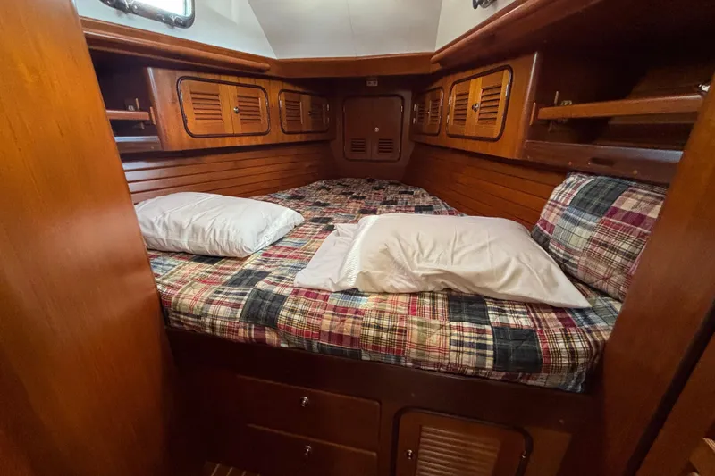 Slide: The Image of Cozy cabin interior of 2002 Passport 470 Center Cockpit sailboat with plaid bedding. - 75