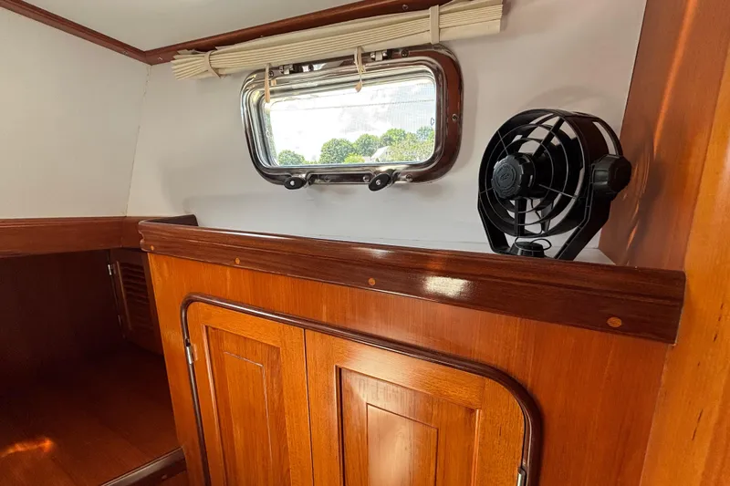 Slide: The Image of Interior of 2002 Passport 470 Center Cockpit with wooden cabinetry and a small fan. - 66