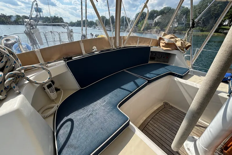 Slide: The Image of Cockpit of 2002 Passport 470 Center Cockpit sailboat with blue cushions and scenic water view. - 19