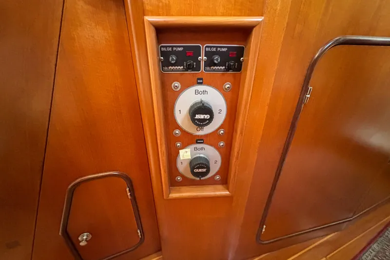 Slide: The Image of Control panel on a 2002 Passport 470 Center Cockpit yacht, featuring bilge pump switches. - 53