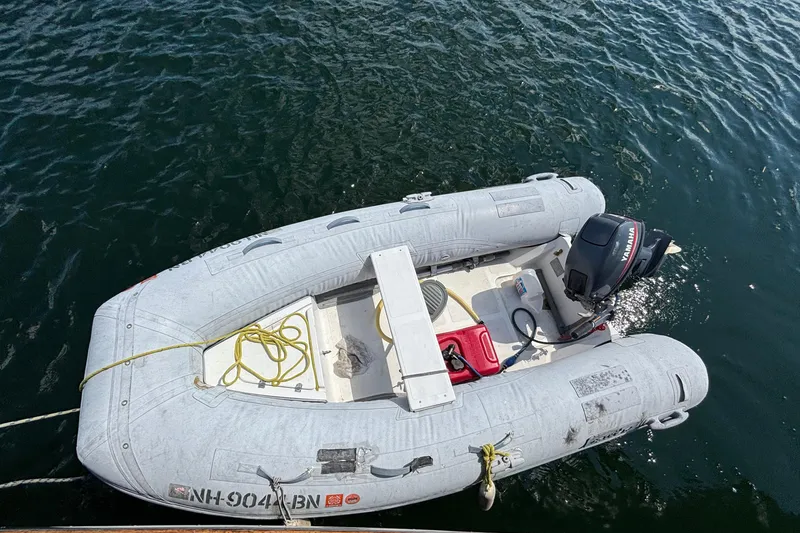 Slide: The Image of Inflatable dinghy with Yamaha motor on water, near Passport 470 Center Cockpit, 2002 model. - 91