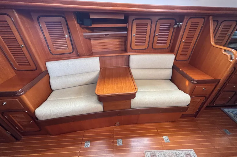 Slide: The Image of Luxurious wooden interior of a 2002 Passport 470 Center Cockpit yacht with cushioned seating. - 43